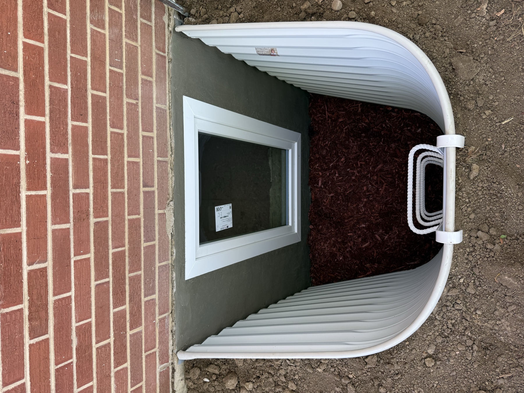 Finished egress window parged opening white well Colorado